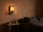 Travertine wall sconce glowing warm in a minimalist bedroom